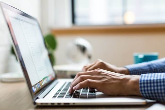 Person working on a laptop to improve service page authority through clearer website content and stronger service pages.